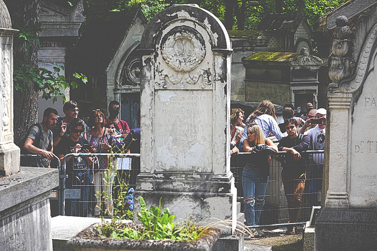 Fans gather at the tomb of rock singer Jim Morrison at the Pere-Lachaise cemetery in Paris, Saturday, July 3, 2021. Fans across Europe gathered at the grave of rock legend Jim Morrison to mark the 50th anniversary of his death.(AP Photo/Michel Euler)